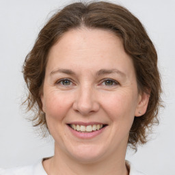 Joyful white adult female with medium  brown hair and grey eyes