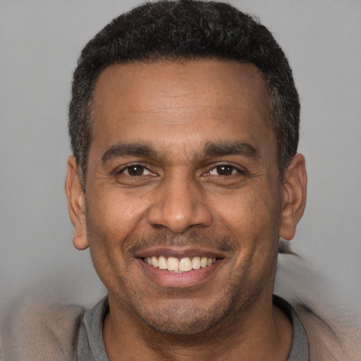 Joyful latino adult male with short  brown hair and brown eyes