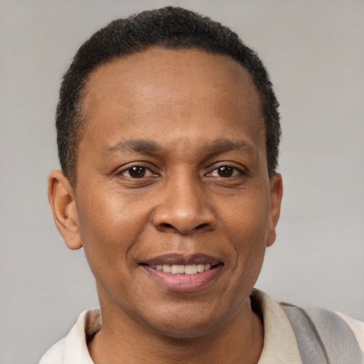 Joyful black adult male with short  brown hair and brown eyes