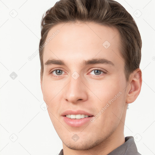 Joyful white young-adult male with short  brown hair and grey eyes