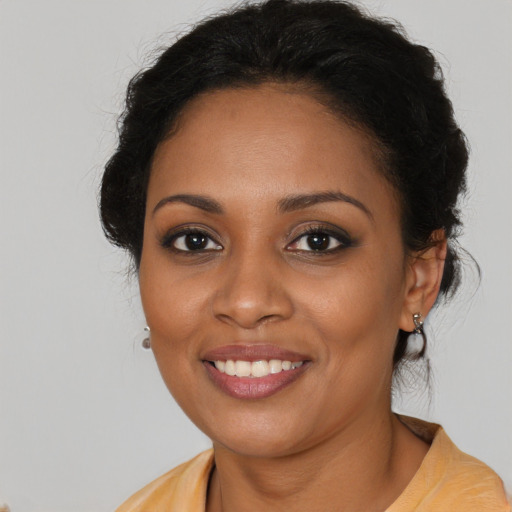 Joyful black young-adult female with long  brown hair and brown eyes