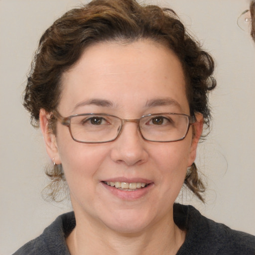 Joyful white adult female with medium  brown hair and blue eyes