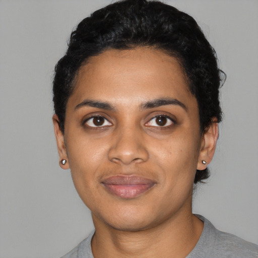 Joyful black young-adult female with short  black hair and brown eyes