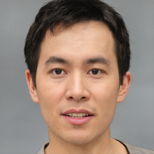 Joyful asian young-adult male with short  brown hair and brown eyes