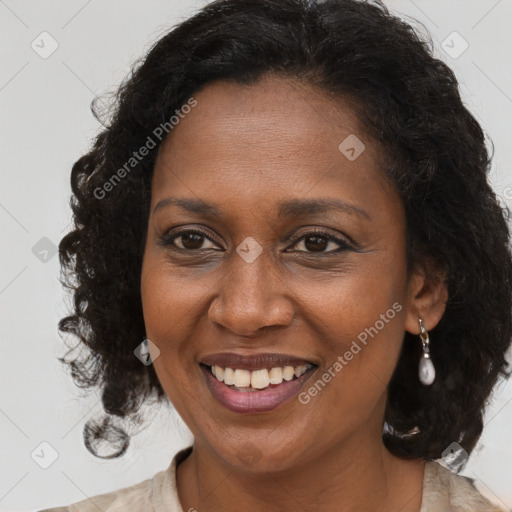 Joyful black adult female with long  brown hair and brown eyes