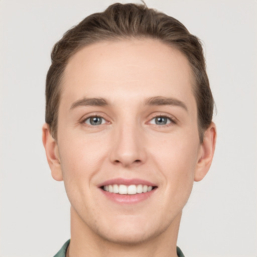 Joyful white young-adult male with short  brown hair and grey eyes