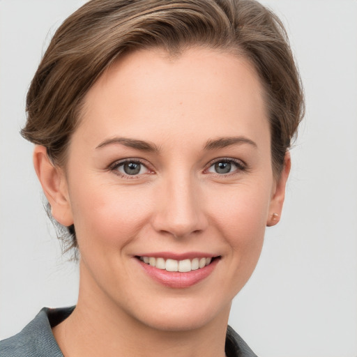 Joyful white young-adult female with short  brown hair and grey eyes