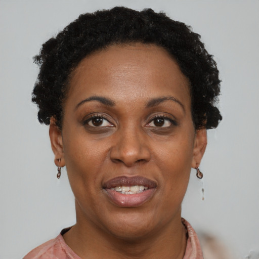Joyful black young-adult female with short  brown hair and brown eyes