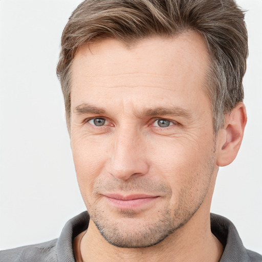 Joyful white adult male with short  brown hair and grey eyes