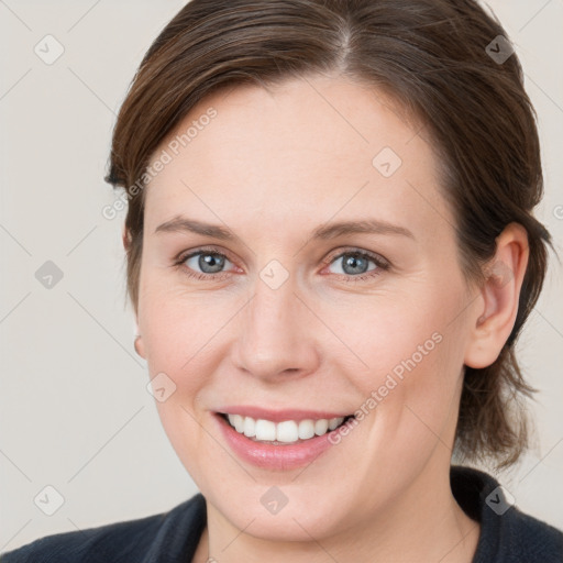 Joyful white young-adult female with medium  brown hair and grey eyes