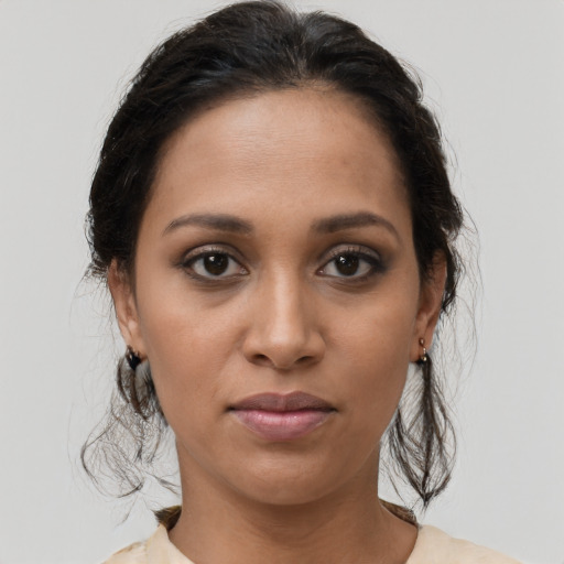 Joyful latino young-adult female with medium  brown hair and brown eyes
