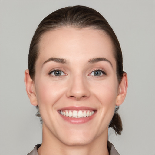 Joyful white young-adult female with short  brown hair and grey eyes