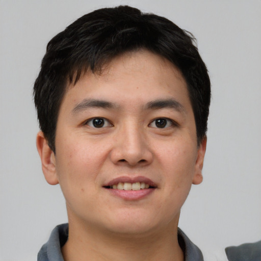 Joyful asian young-adult male with short  black hair and brown eyes