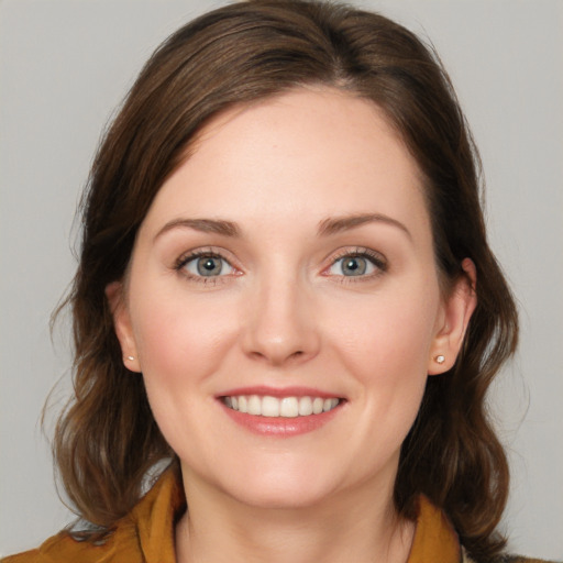 Joyful white young-adult female with medium  brown hair and blue eyes