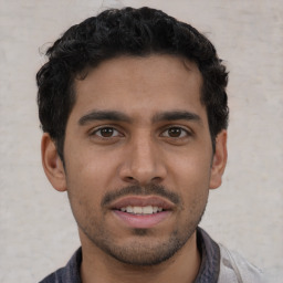 Joyful latino young-adult male with short  brown hair and brown eyes