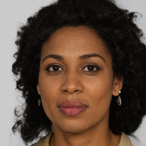 Joyful black young-adult female with long  black hair and brown eyes