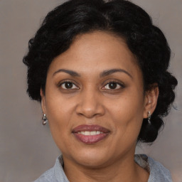 Joyful latino adult female with medium  brown hair and brown eyes
