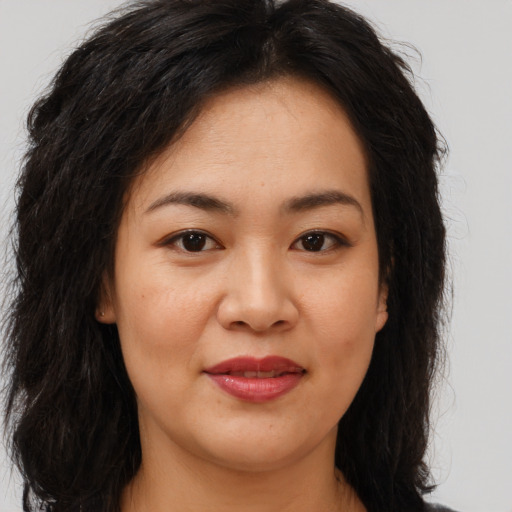 Joyful asian young-adult female with long  brown hair and brown eyes