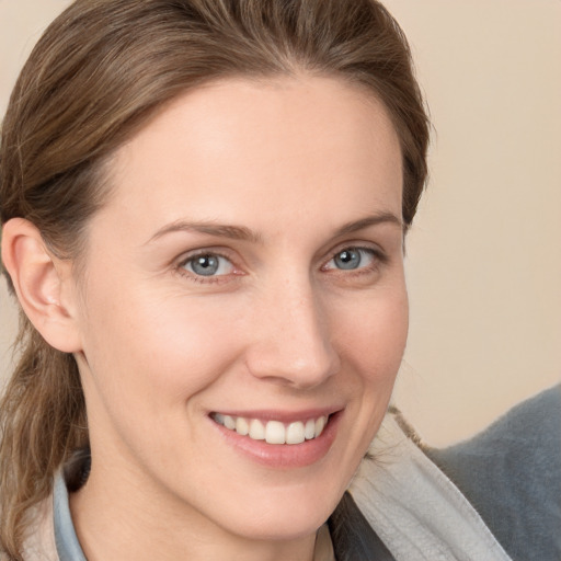 Joyful white young-adult female with medium  brown hair and grey eyes