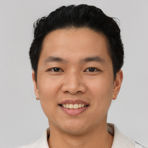 Joyful asian young-adult male with short  black hair and brown eyes