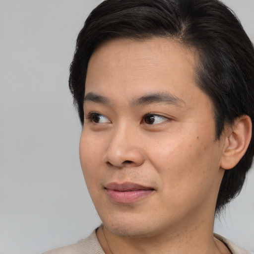 Joyful asian young-adult male with short  brown hair and brown eyes