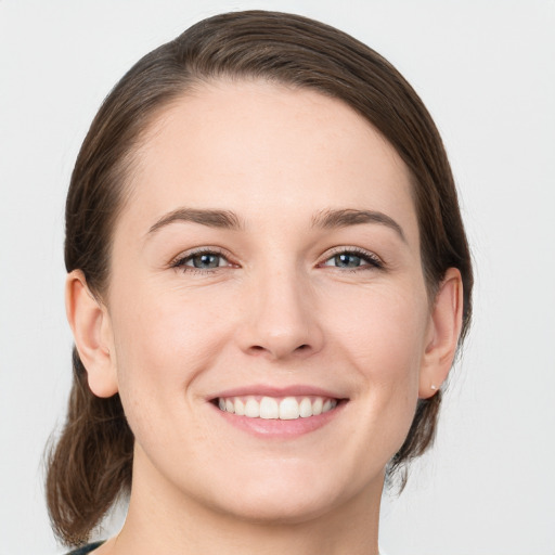 Joyful white young-adult female with medium  brown hair and grey eyes