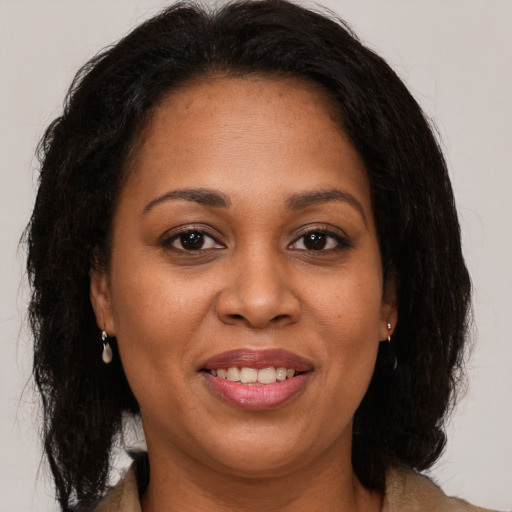 Joyful black adult female with medium  brown hair and brown eyes