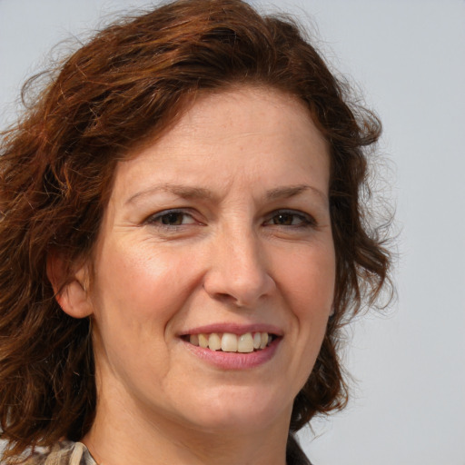 Joyful white adult female with medium  brown hair and blue eyes