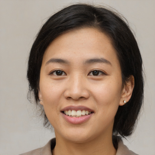 Joyful asian young-adult female with medium  brown hair and brown eyes