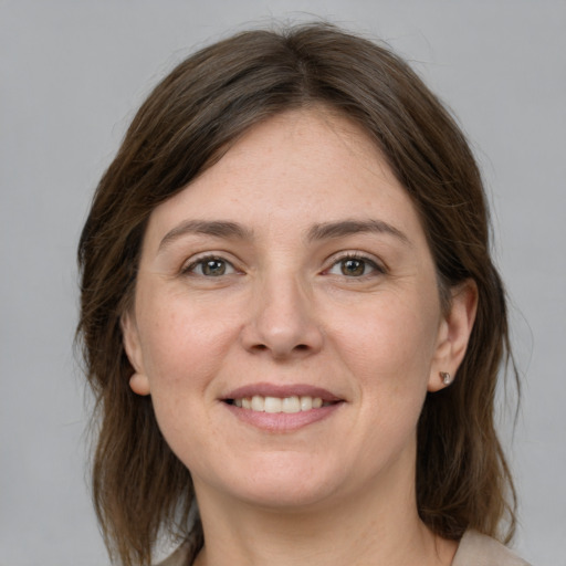 Joyful white young-adult female with medium  brown hair and grey eyes