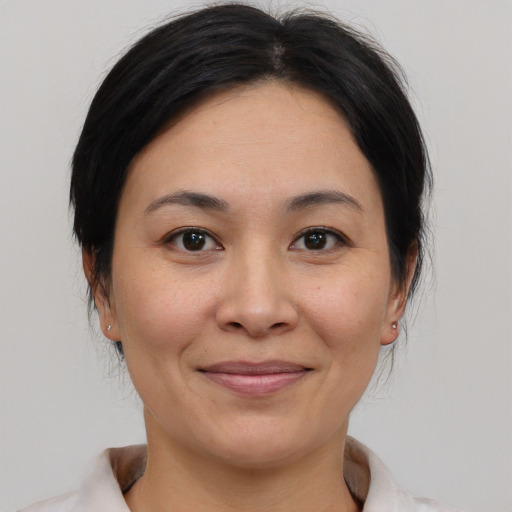 Joyful asian young-adult female with medium  brown hair and brown eyes