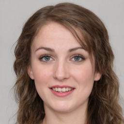 Joyful white young-adult female with medium  brown hair and green eyes