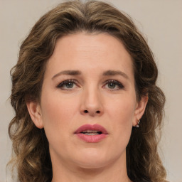 Joyful white young-adult female with medium  brown hair and green eyes