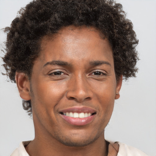 Joyful black young-adult male with short  brown hair and brown eyes