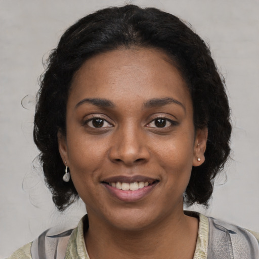 Joyful black young-adult female with medium  brown hair and brown eyes