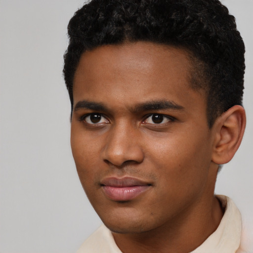 Joyful black young-adult male with short  black hair and brown eyes