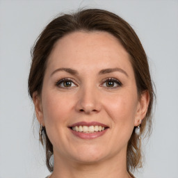 Joyful white adult female with medium  brown hair and grey eyes