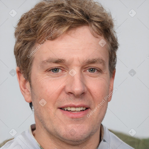 Joyful white adult male with short  brown hair and grey eyes