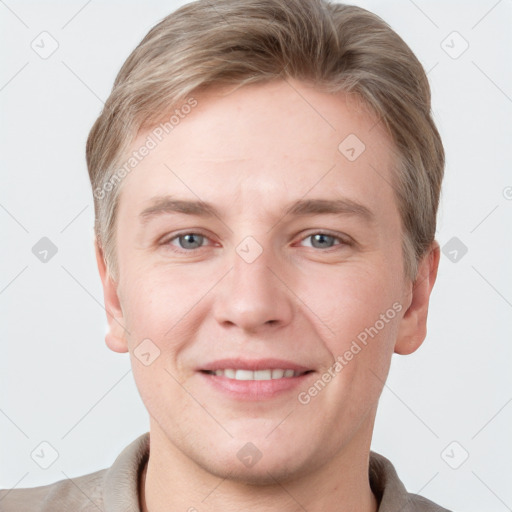 Joyful white young-adult male with short  brown hair and grey eyes