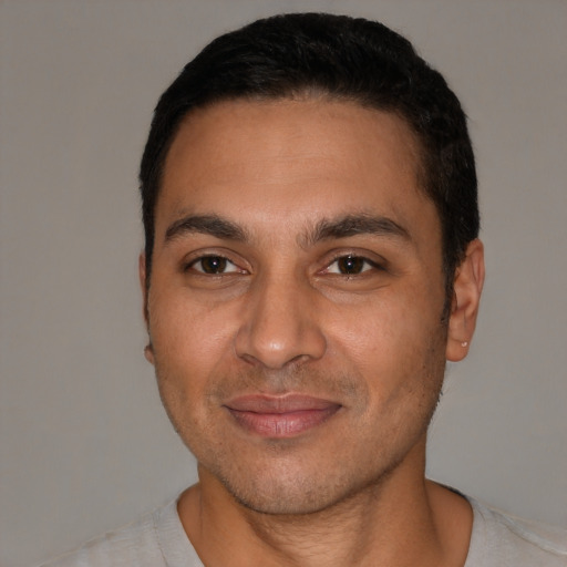 Joyful white young-adult male with short  black hair and brown eyes