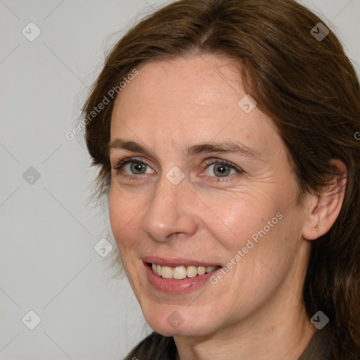 Joyful white adult female with long  brown hair and brown eyes