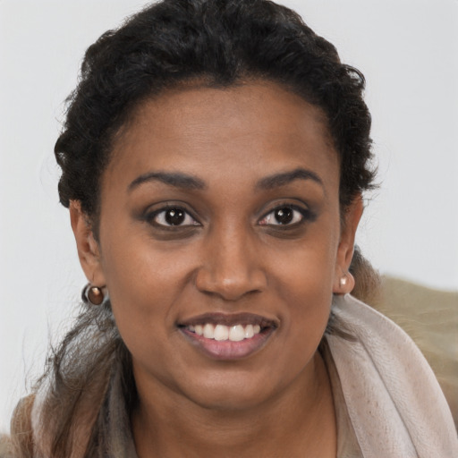 Joyful black young-adult female with short  brown hair and brown eyes