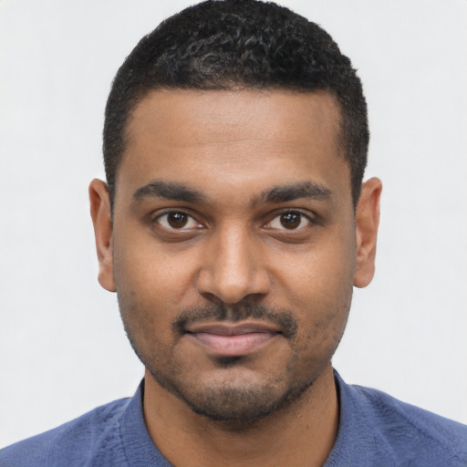 Joyful black young-adult male with short  black hair and brown eyes