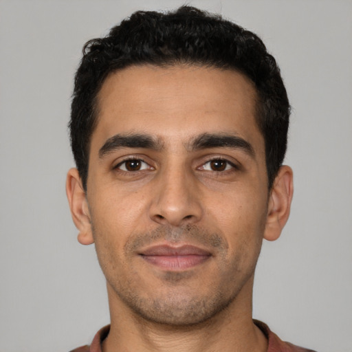 Joyful latino young-adult male with short  black hair and brown eyes