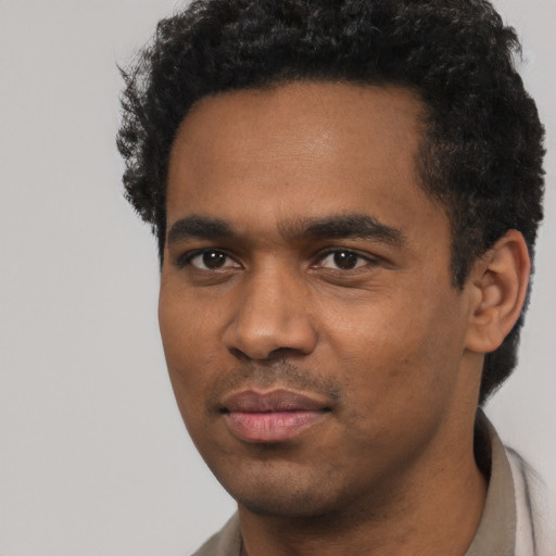 Joyful black young-adult male with short  black hair and brown eyes