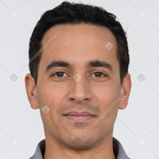 Joyful latino young-adult male with short  black hair and brown eyes