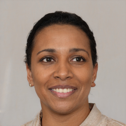 Joyful latino young-adult female with short  black hair and brown eyes