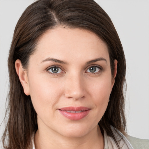 Joyful white young-adult female with medium  brown hair and grey eyes