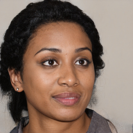 Joyful black young-adult female with medium  black hair and brown eyes