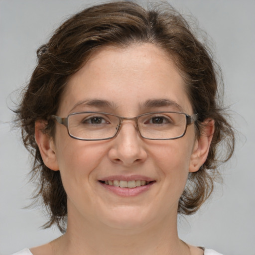 Joyful white adult female with medium  brown hair and green eyes